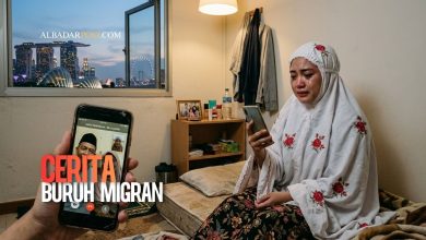 Pekerja migran Indonesia duduk sendiri di kamar luar negeri sambil melakukan panggilan video dengan keluarga di rumah.