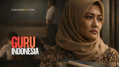 Guru Indonesia sedang mengajar di kelas dengan laptop dan buku pelajaran menggambarkan tantangan guru di era digital