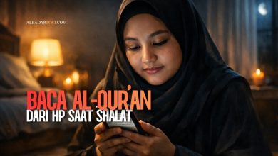 Wanita muslim membaca Al-Qur’an dari HP saat shalat malam di kamar dengan suasana tenang dan khusyuk.