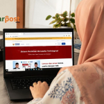 Staff Den Legal sedang memeriksa kode KBLI 2025 melalui sistem OSS di laptop