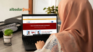 Staff Den Legal sedang memeriksa kode KBLI 2025 melalui sistem OSS di laptop