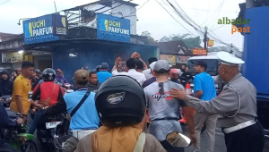 Petugas menghentikan pengendara yang menerobos jalur pelari QRIS Unsil Tasik Half Marathon 2026 di Tasikmalaya.