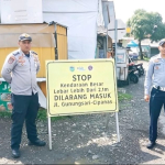 Petugas Dishub berjaga di perempatan Jalan Gunungsari Cipanas Tasikmalaya sambil mengawasi truk tambang pasir.