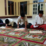 Santri pesantren sedang mengkaji Kitab Safinatun Najah tentang hukum batal wudhu dan larangan menyentuh mushaf Al-Qur’an.