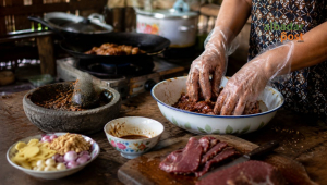 Proses membuat dendeng daging sapi kurban dengan bumbu rempah di dapur rumah tradisional